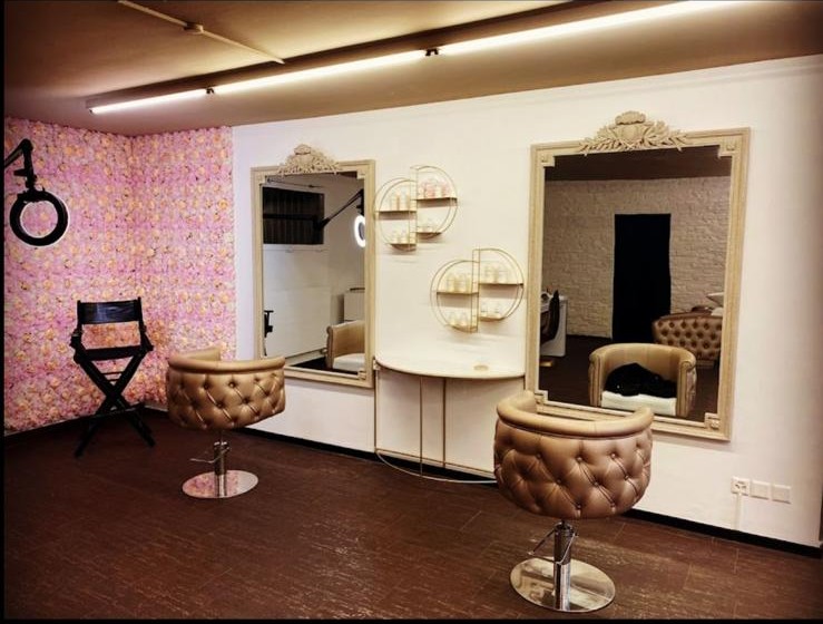 Innenraum des Salons Hairbysonguel in Dübendorf mit Stylingplätzen, grossen Spiegeln und Blumenwand